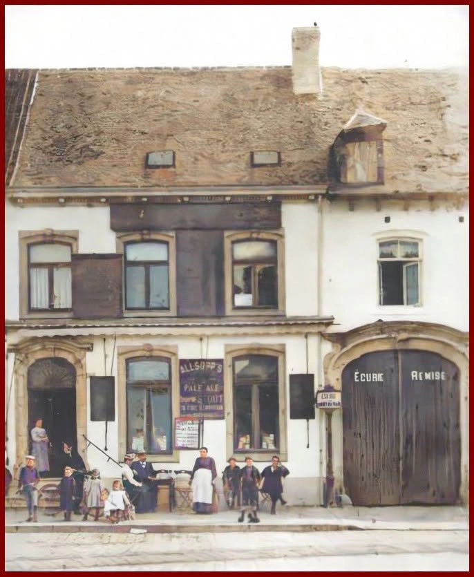 Vue ancienne de la façade de l’auberge de Waterloo, avec des personnes devant l’entrée